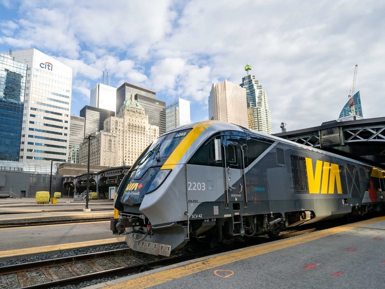 Passenger train travelling through a scenic Canadian landscape